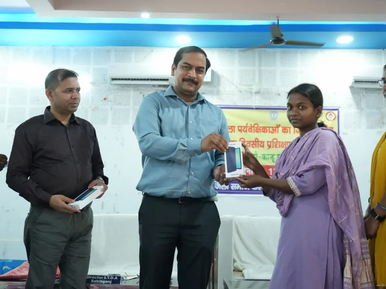 प्रशिक्षण कार्यक्रम के दौरान प्रशिक्षण महिला पर्यवेक्षिका को मोबाइल देते साहिबगंज उपायुक्त